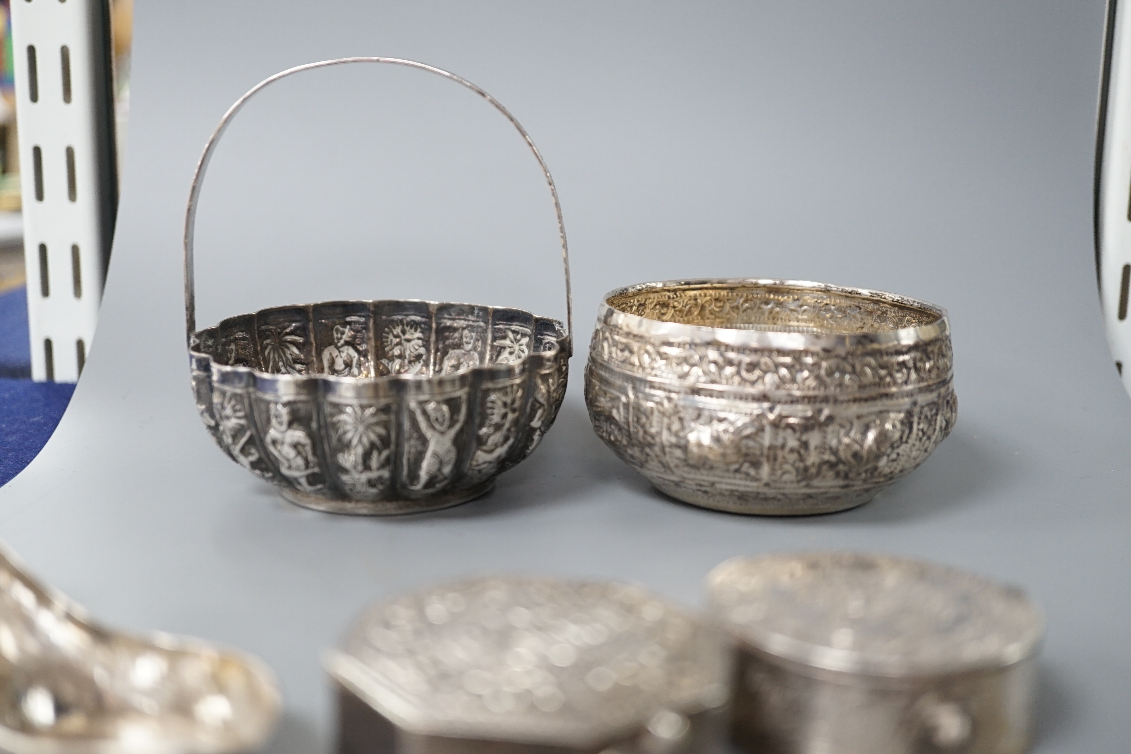 A Burmese? white metal bonbon basket, height 10.1cm and a similar bowl, two Persian white metal boxes and a spoon.